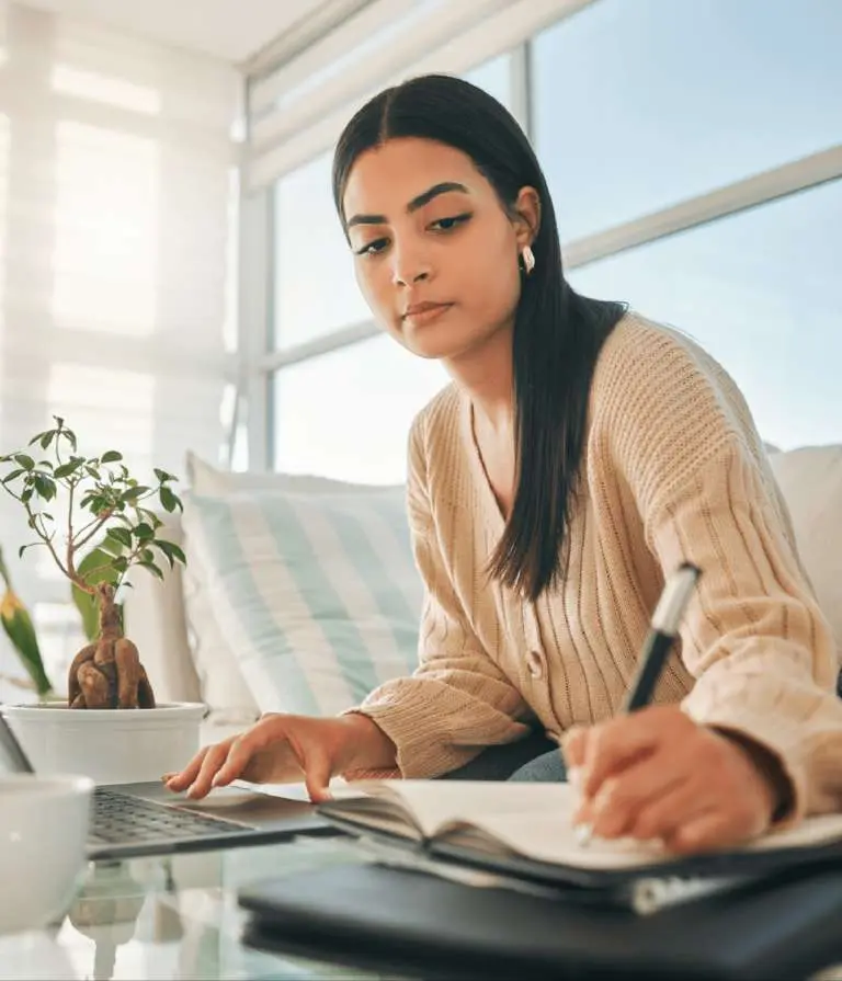 young adult filling in an application online and taking notes